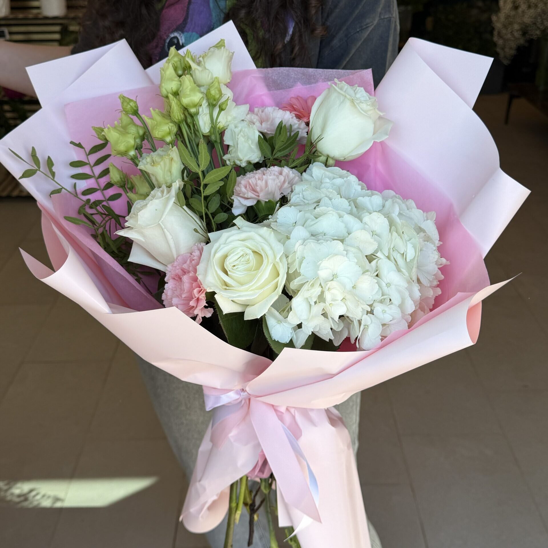 Buchet elegant cu hortensie albă, trandafiri albi și lisianthus, ambalat în roz pastel