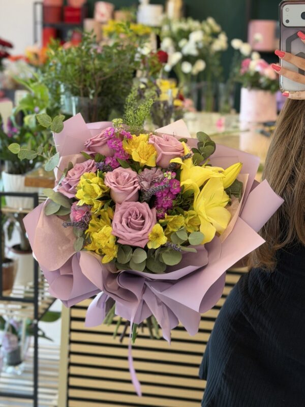 Buchet premium cu trandafiri lila, crini galbeni și alstroemeria, realizat în florăria Fir de Rai Brașov.