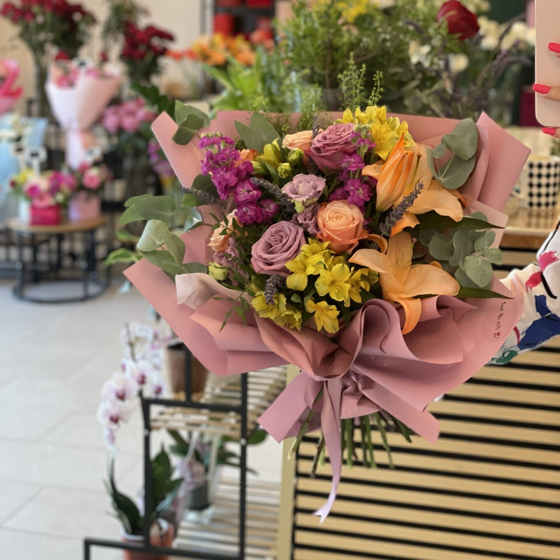 Buchet premium cu trandafiri lila, crini somon, alstroemeria galbenă și mathiola mov, realizat în florăria Fir de Rai Brașov.