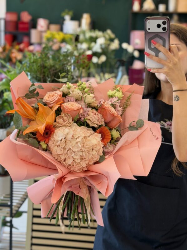 Buchet premium cu hortensie piersică, crin portocaliu, trandafiri peach și garoafe cappuccino, realizat în florăria Fir de Rai Brașov