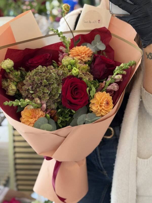 Buchet premium cu trandafiri bordo, hortensie verde-antique, dalii portocalii și eucalipt, ambalat elegant în tonuri nude.