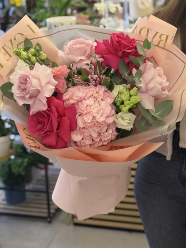 Buchet premium cu hortensie roz, trandafiri fucsia și roz pudrat, lisianthus și eucalipt, ambalat elegant în nuanțe pastel.