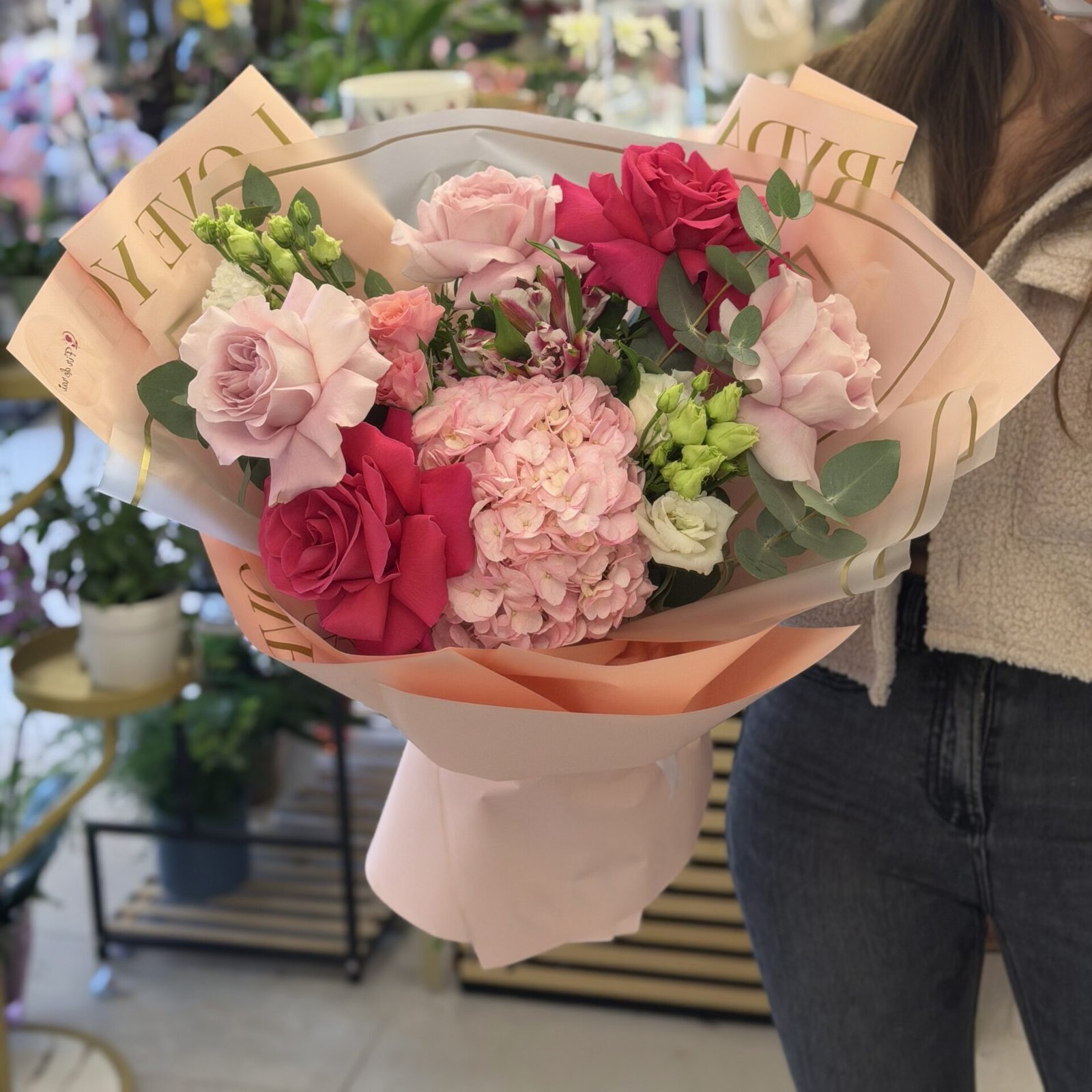 Buchet premium cu hortensie roz, trandafiri fucsia și roz pudrat, lisianthus și eucalipt, ambalat elegant în nuanțe pastel.